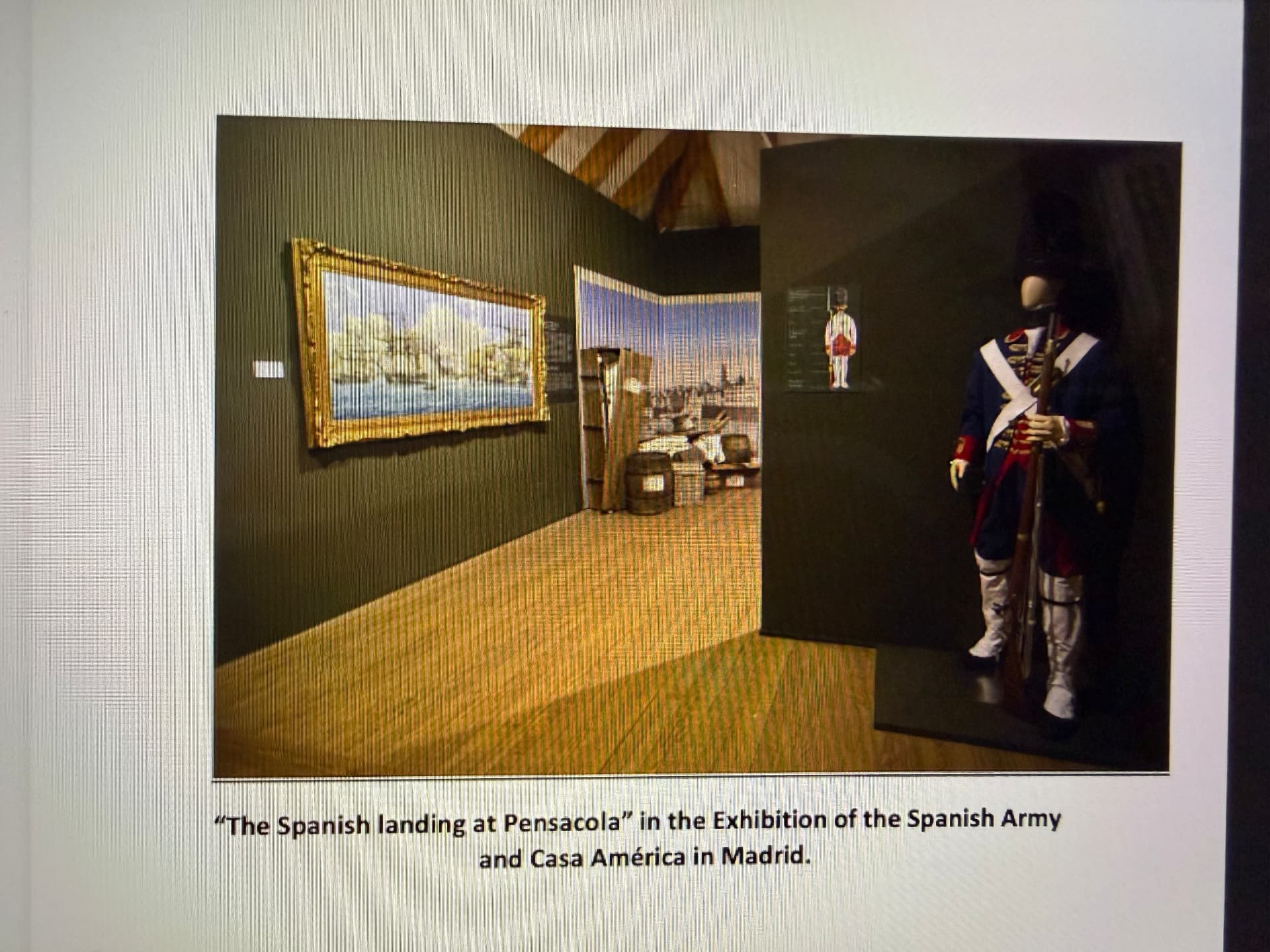 Sala de exposición con paredes verde oliva: a la izquierda el óleo de Pensacola enmarcado, a la derecha un maniquí con uniforme de granadero español del siglo XVIII
